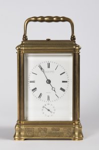 A TRAVEL ALARM CLOCK IN A CABINET